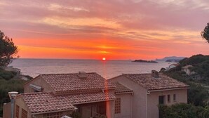 A coastal sunset view with terracotta-roofed buildings. - Apartment type villa in Sanary sea view, 150m from the beach with Jacuzzi plus parking (Sanary-sur-Mer)