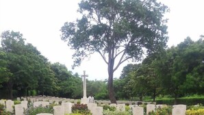A cemetery with headstones and crosses, surrounded by greenery and flowers. - Nilaveli Beach Rooms (Nilaveli)