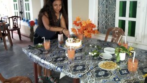 A dining area with a table set for a meal, featuring a cake and various dishes. - Nilaveli Beach Rooms (Nilaveli)