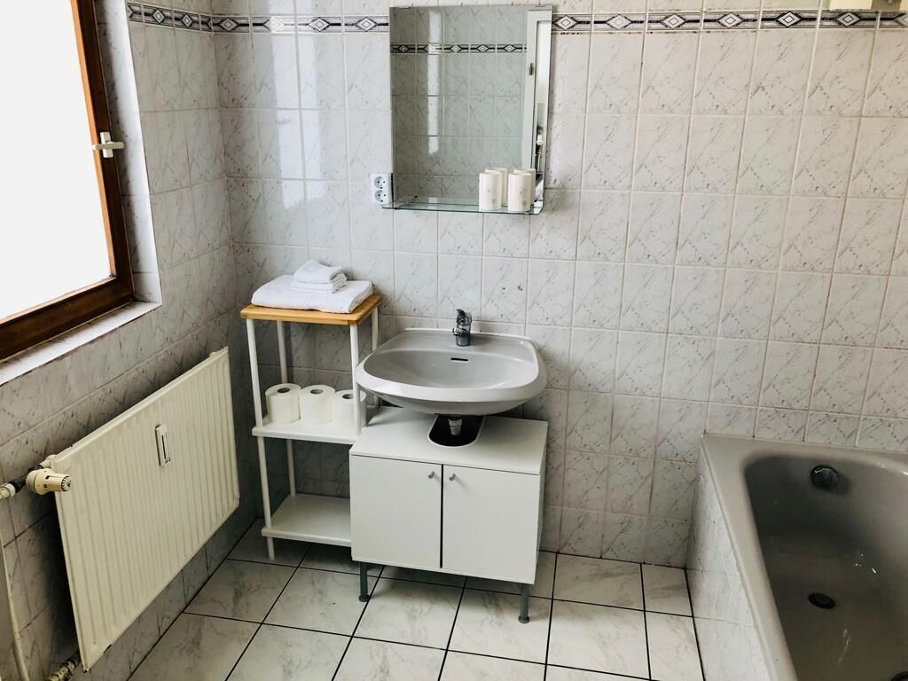 Een bad/douchecombinatie, een haardroger, handdoeken, zeep