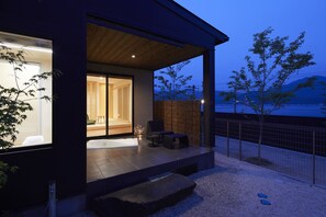A modern house with a covered porch, a visible bathroom, and a view of the outdoors. - Miyajima Hanarenoyado IBUKU Bettei (Hatsukaichi)