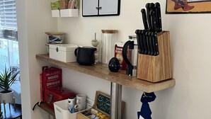 Eine Küchenarbeitsplatte mit einem Kalender, einer Kaffeemaschine, einem Messerblock und einem Feuerlöscher.