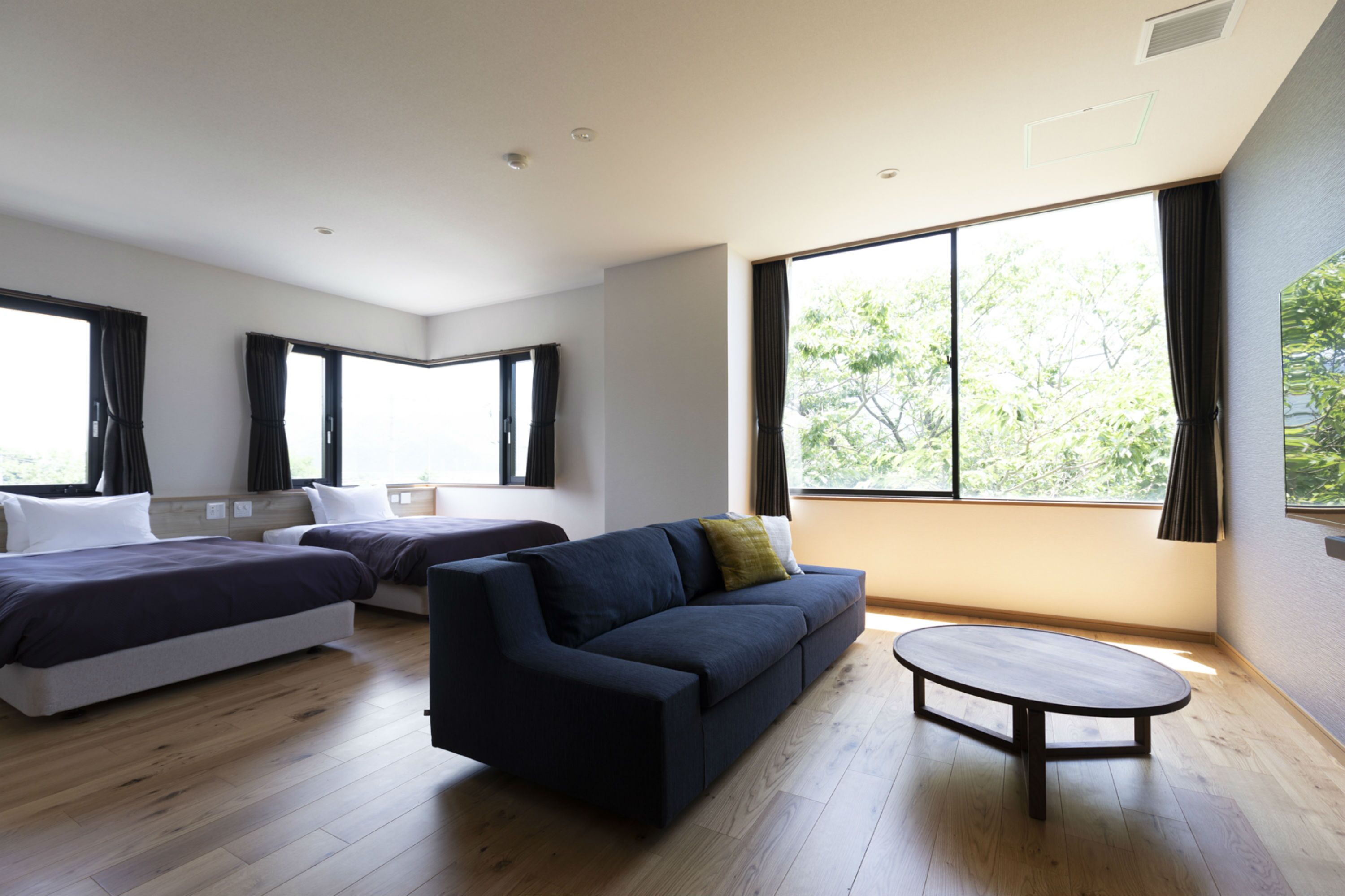 Una habitación moderna con dos camas, un sofá y una mesita.
