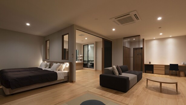 Une chambre d’hôtel moderne, dotée d’un grand lit, d’un canapé, d’un bureau et d’une chaise.