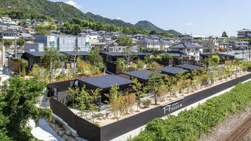 A residential area with modern houses, a train track, and a mountainous backdrop.