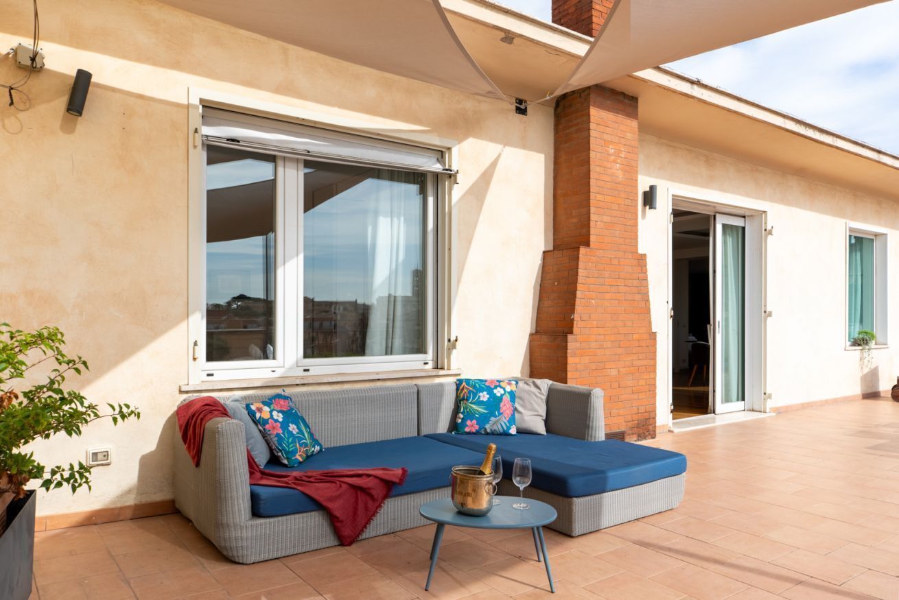 Ein Balkon mit einer Couch, einem kleinen Tisch und einem Blumentopf.