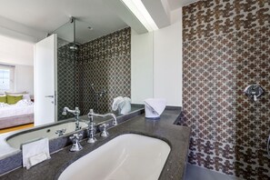 A modern bathroom with a large mirror, a bathtub, and a shower.