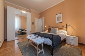 Quarto com cama, mesa de cabeceira e espelho.