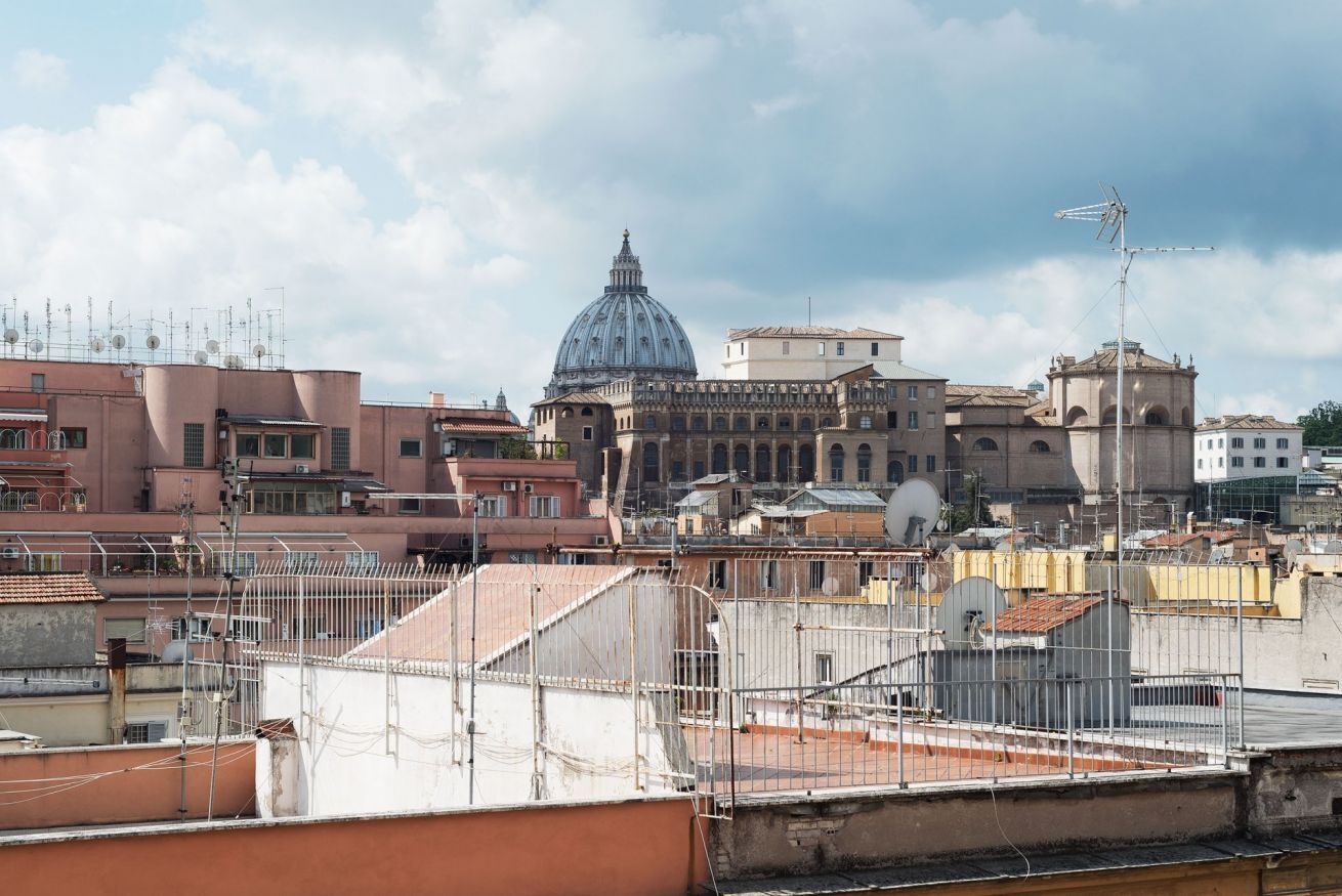 Une vue urbaine mettant en valeur un imposant dôme, vraisemblablement celui d’un bâtiment historique ou religieux, entouré d’immeubles résidentiels, le tout sous un ciel dégagé.