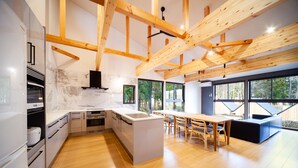 Una cocina moderna con vigas de madera, salpicadero de mármol y una isla grande.