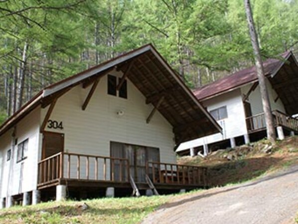A cabin with a number '304' on its side, wooden exterior, and a porch with a railing.