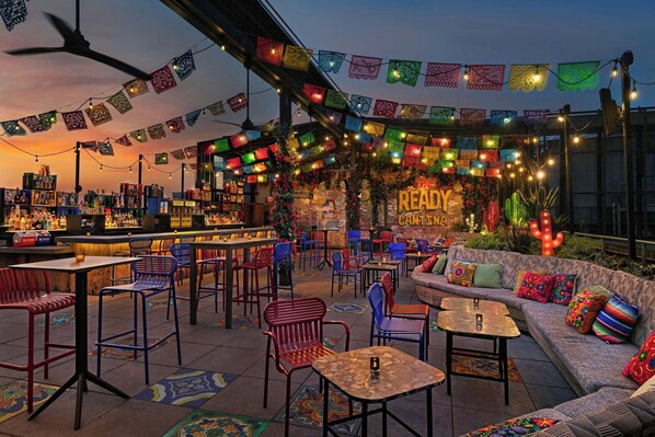 A bar area with colorful lanterns, a bar counter, and seating arrangements.
