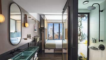 Une salle de bain moderne avec une douche à parois de verre, un lavabo vert et un grand miroir.