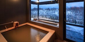 A sauna with a view of a snowy forest.