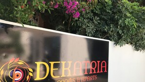 Un letrero que dice 'DERATRIA ROOMS & APARTS' con un logotipo colorido.