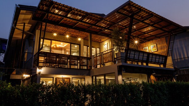 A modern two-story building with large windows, balconies, and a covered outdoor area. - Hostel One Art & Gallery (Chiang Mai)