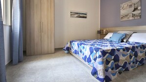 Une chambre à coucher avec un lit, une armoire et un tableau accroché au mur.