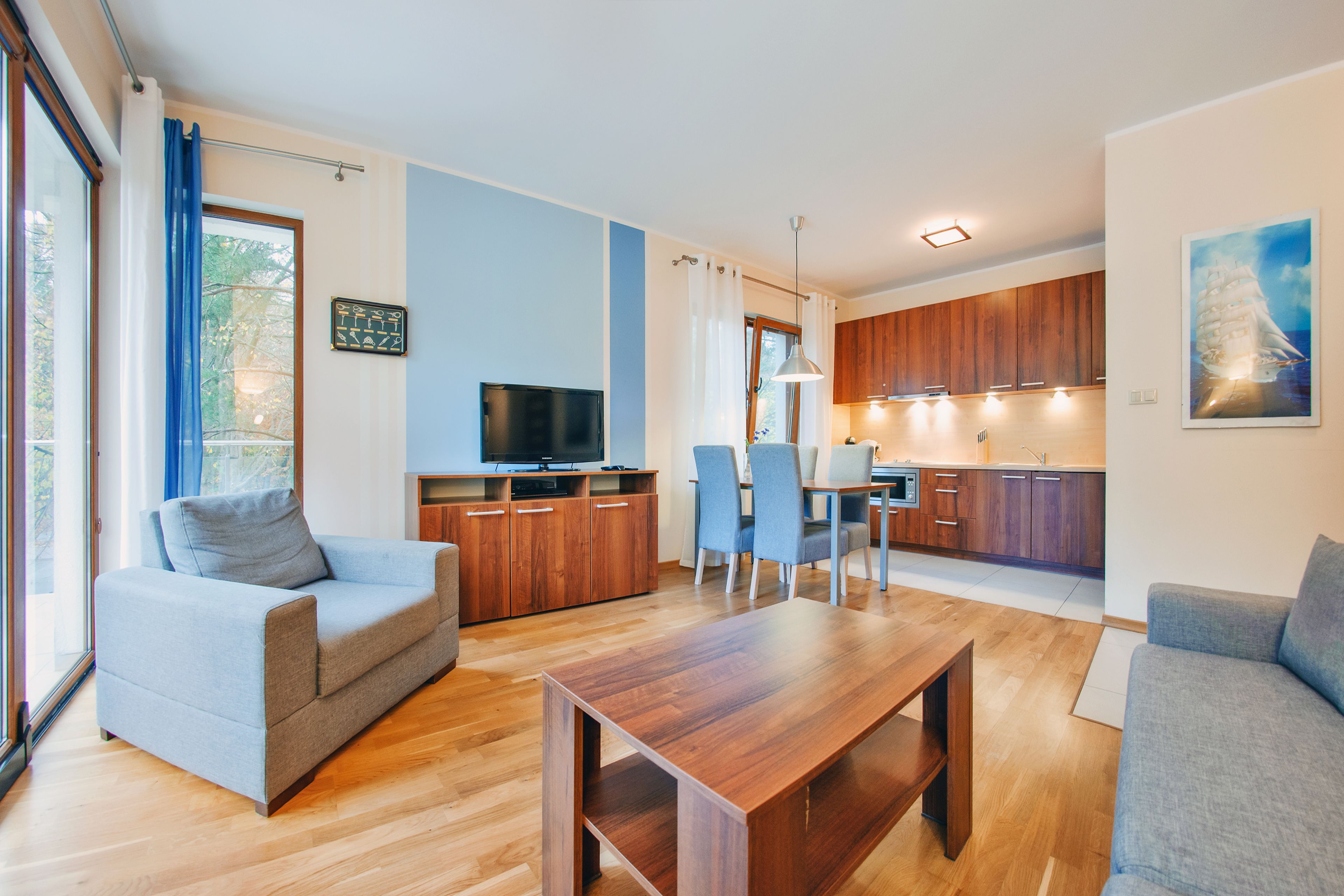 Un soggiorno moderno con un tavolino in legno, divani grigi e una TV.