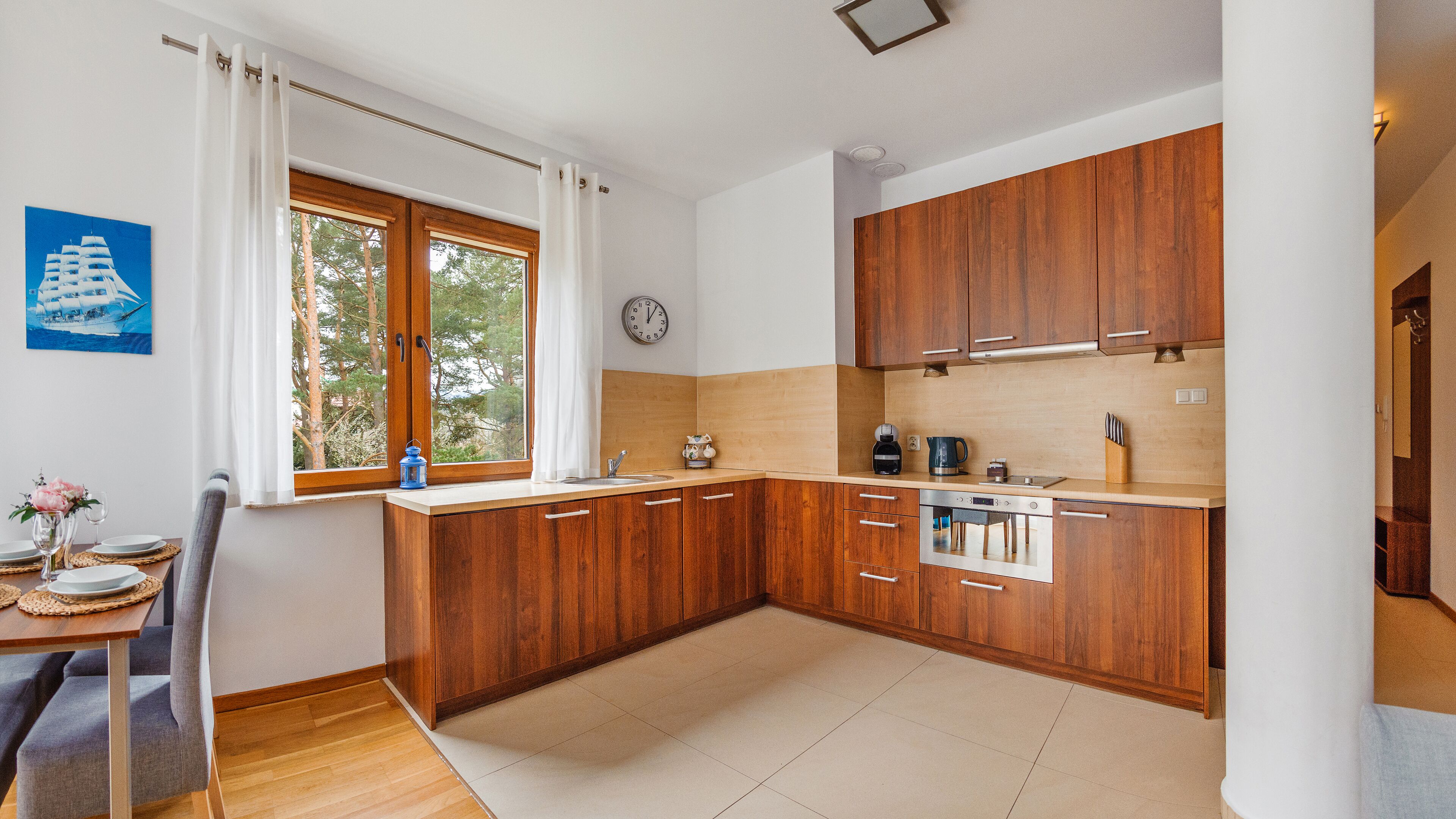 Una cocina moderna con armarios de madera, un lavamanos y un reloj en la pared.