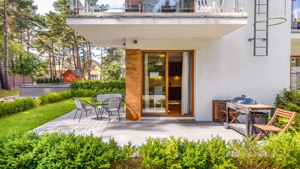 A modern house with a balcony, outdoor seating, and a barbecue area. - Apartamenty Sun & Snow Cztery Pory Roku (Wladyslawowo)
