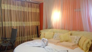 A hotel room with a bed, a chair, and curtains. - Chester View Homestay - Hostel (Mlolongo)