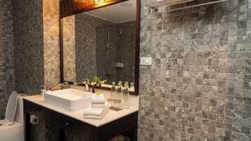 A bathroom with a white sink, dark wooden vanity, and a large mirror.