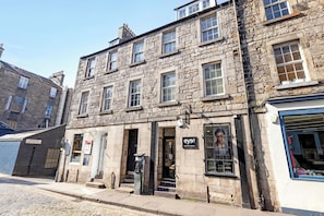 A stone building with multiple windows and a storefront. - JOIVY Thistle Street - Heart of the City 2-bedroom Apt (Edinburgh)
