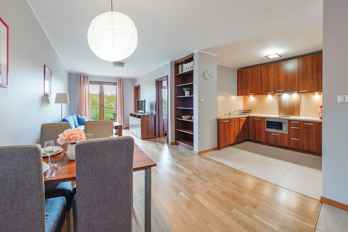 A modern apartment with a dining area, living room, and kitchen.