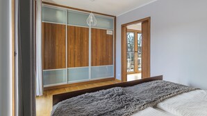 Un dormitorio con cama, armario y ventana.