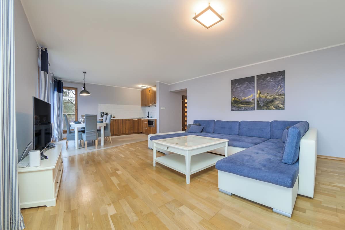 A modern living room with a sectional sofa, a coffee table, and a TV.