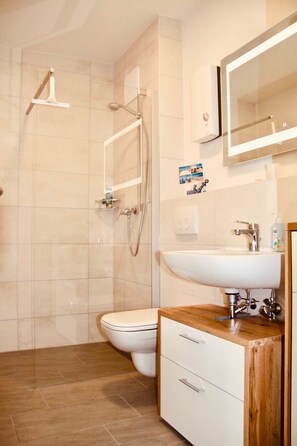 Een douche, een haardroger, zeep, toiletpapier