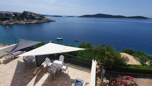 A terrace with a table and chairs, overlooking a coastal area with boats and buildings. - Apartment in Sevid with Seaview, Terrace, Air condition, WIFI (4746-3) (Sevid)