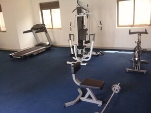 Une salle de sport équipée de tapis de course, d’appareils de musculation et de vélos d’appartement.