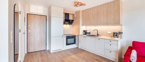 Eine kompakte Küche mit Einbauofen, Spüle und Holzausstattung.