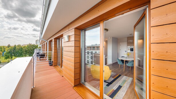Un apartamento moderno con balcón, comedor y cocina.