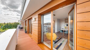 Een modern appartement met balkon, een eethoek en een keuken.