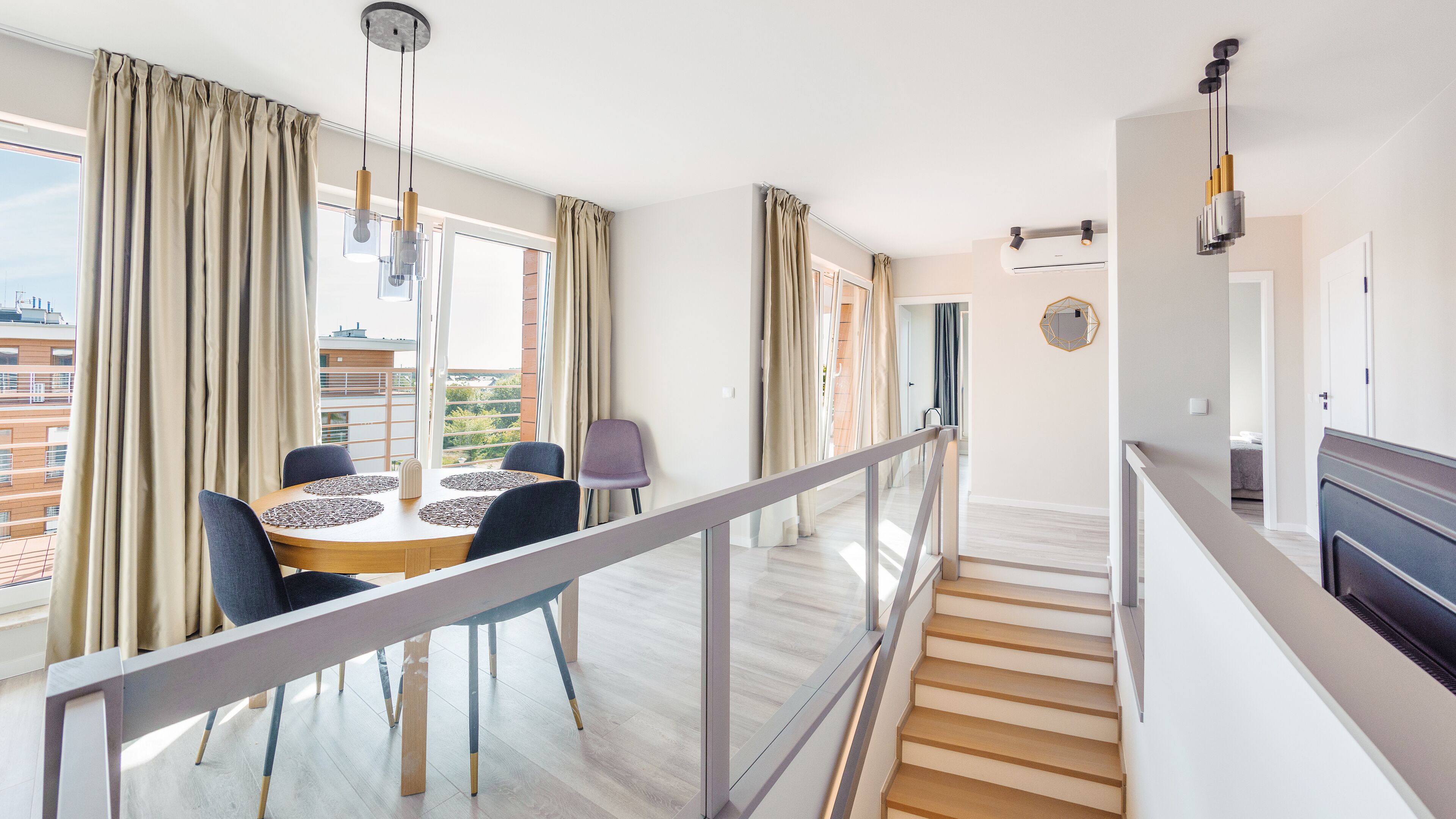 Un apartamento moderno con comedor, una escalera y vistas de la ciudad.