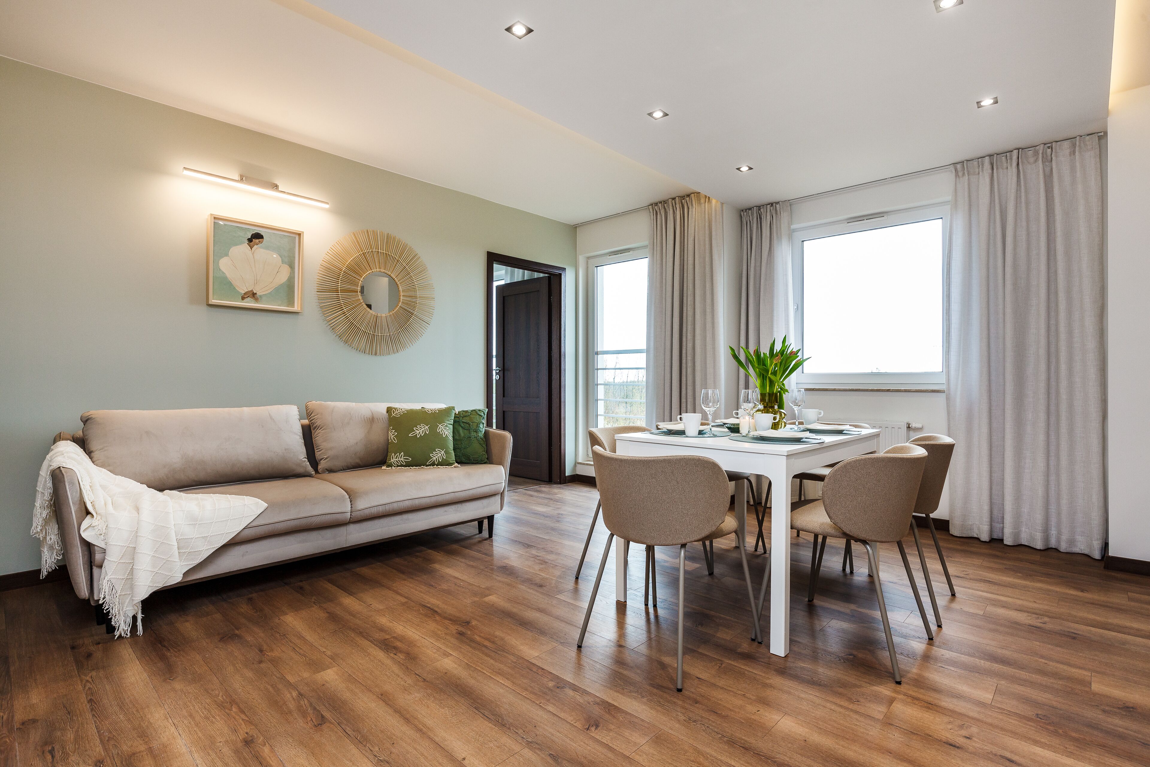 A modern living room with a sofa, dining table, and chairs.