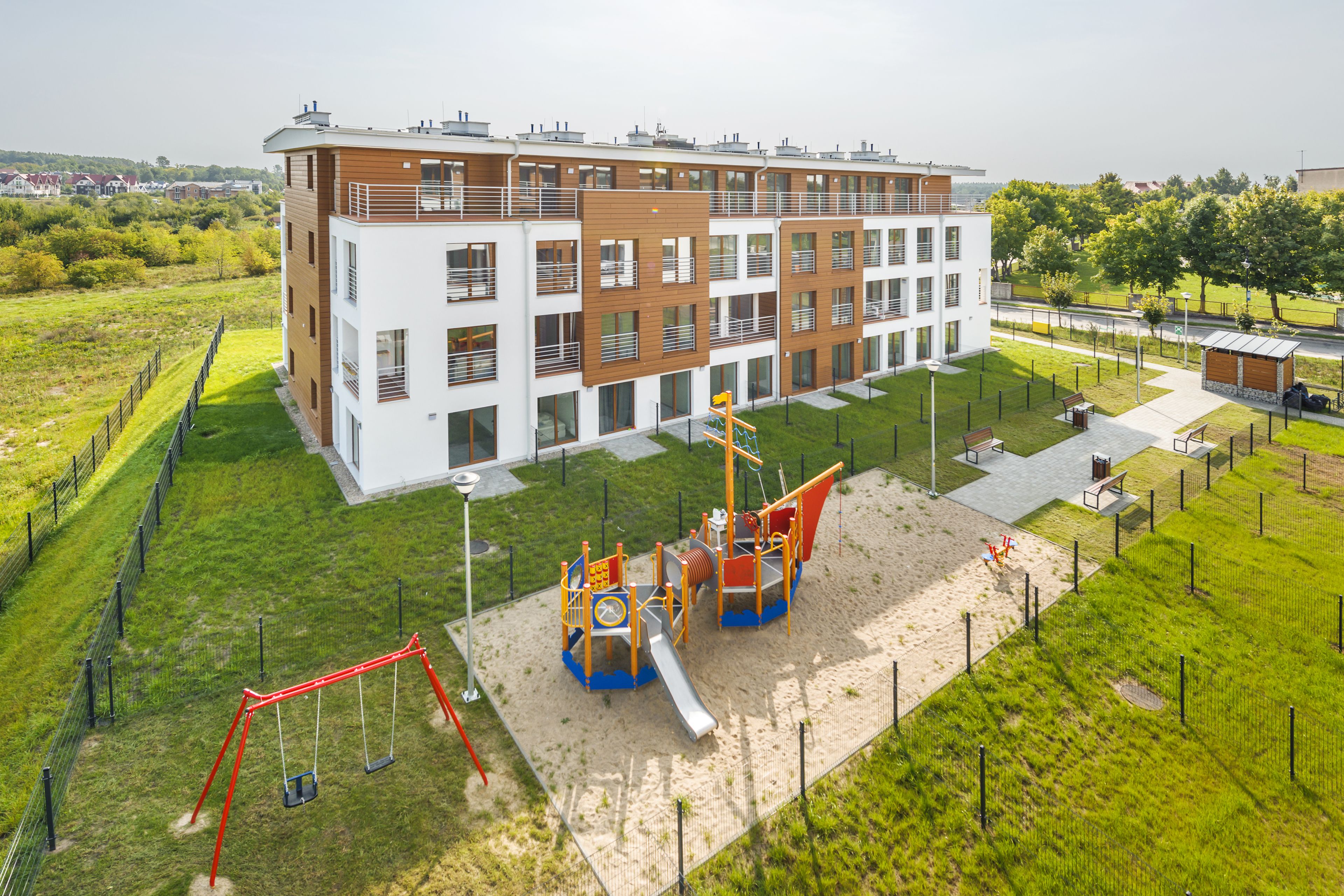 A modern building with a playground in front.