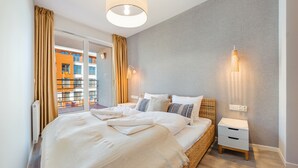 Un dormitorio moderno con una cama grande, una mesita de noche y una lámpara de pared.