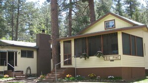 A two-story house with a front porch, labeled "BIG PINE," surrounded by a forest.