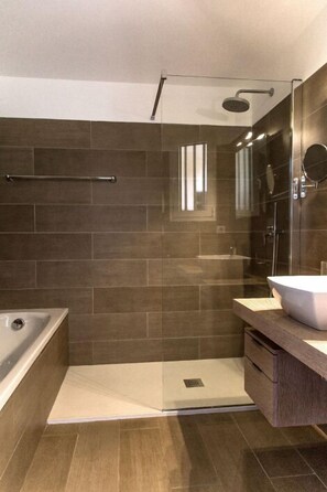Un baño moderno con ducha, bañera y tocador.