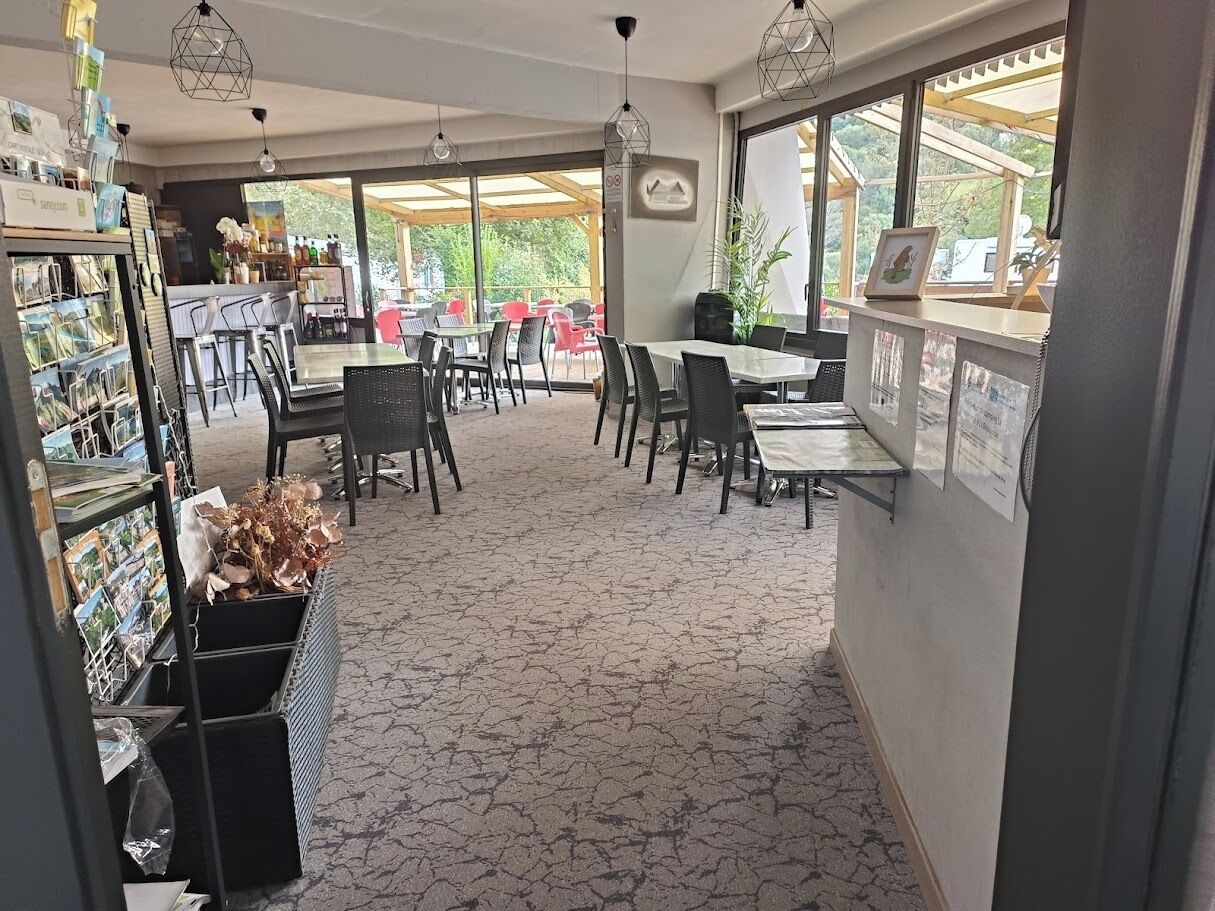 A restaurant with outdoor seating, tables, chairs, and a display of postcards.