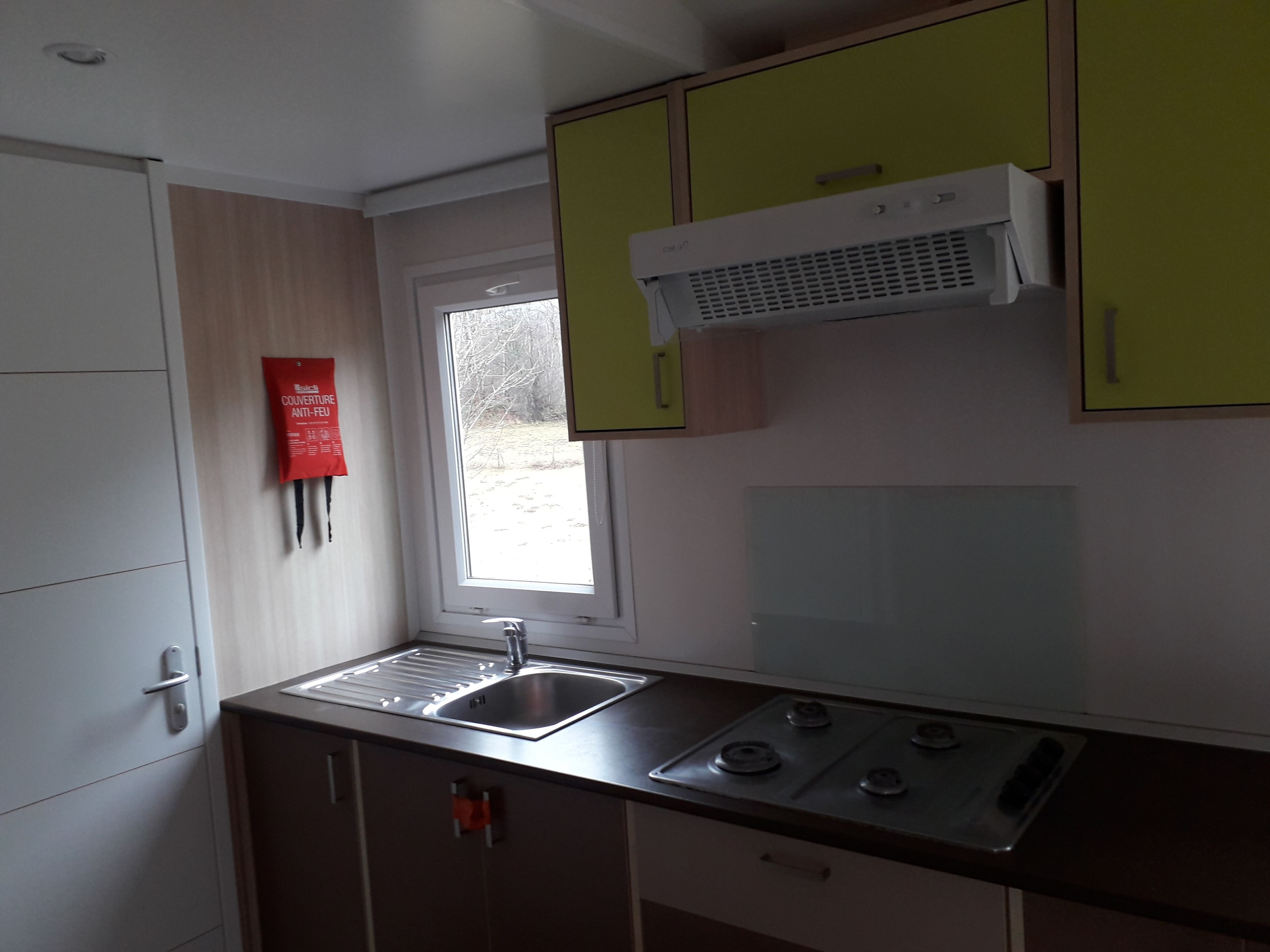 Una cocina compacta con pileta, estufa y alacenas.