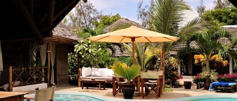 Piscine extérieure, parasols de plage, chaises longues