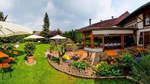 A well-maintained garden with outdoor seating and a covered area. - Harzer Hof (Herzberg am Harz)