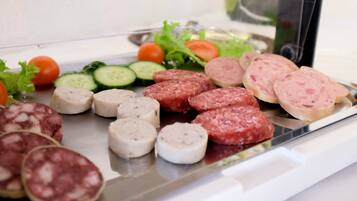 A platter of assorted sliced meats and fresh vegetables.