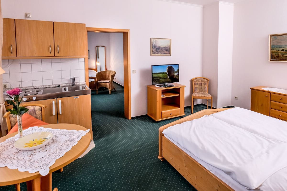 Une chambre d’hôtel avec un lit, un bureau doté d’une lampe, une chaise, un téléviseur et un tableau au mur.