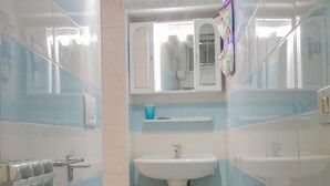 A narrow bathroom with a toilet, sink, and bidet. - Grimaldi Apartments - Jolie (Venice)