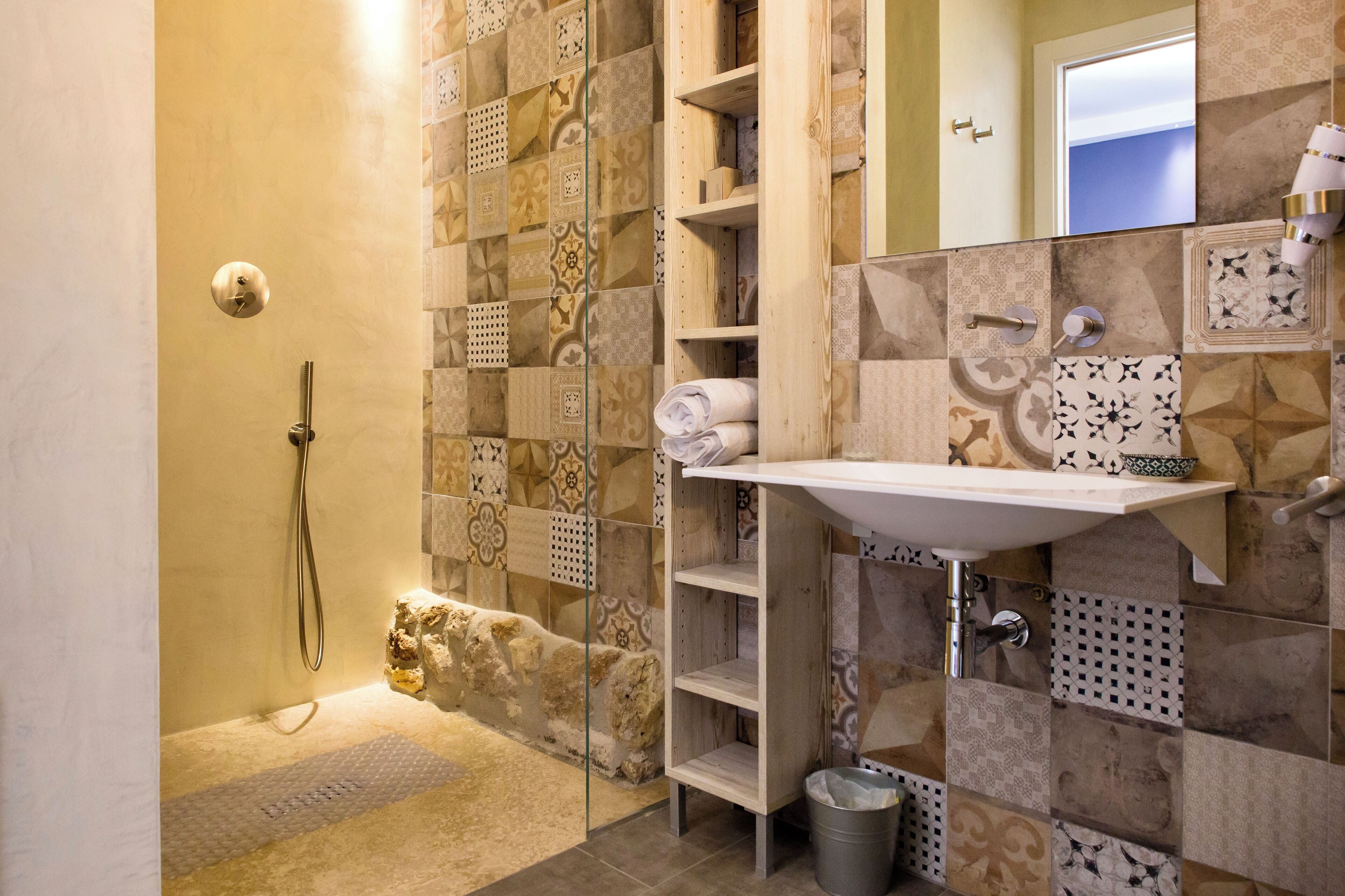 Une salle de bain avec une douche, un lavabo et un miroir.